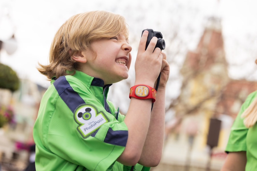 Image of child dressed as Disney PhotoPass cast member taking a photo